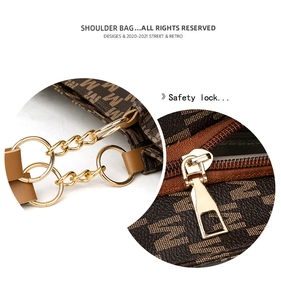 Detail of vintage tote bag featuring gold-tone chain strap and smooth safety metal zipper