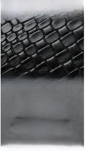 Gros plan sur cuir synthétique noir à texture crocodile et emblème de kangourou doré