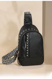 Détail du sac de poitrine noir à rivets avec sangle à motifs sur un présentoir élégant
