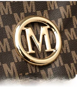 Macro detail of brown pebbled leather bag with beige monogram and golden metal logo