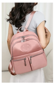 Seitenansicht des leichten mauvefarbenen Nylon-Rucksacks mit Taschen und Kleeblatt-Logo