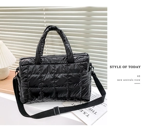 Detail view of black quilted puffer tote bag with top handles and adjustable strap