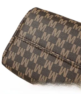 Close-up of deep brown embossed leather with M-letter monogram and precision stitching