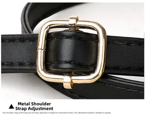 Détail de la bandoulière en cuir noir réglable avec boucle en métal doré poli brillant
