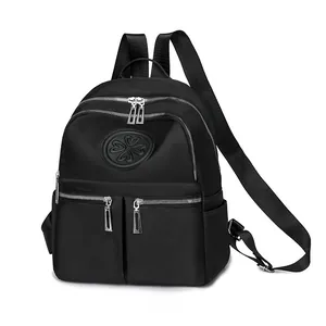 Seitenansicht des schwarzen Nylon-Rucksacks mit Reißverschlusstaschen und Kleeblatt-Logo