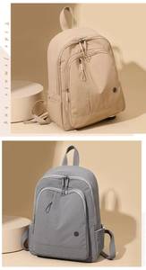 Detail view of beige and grey minimalist nylon backpacks with multiple compartments