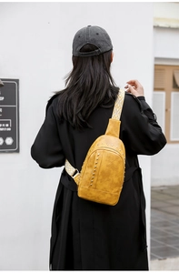 Détails de la sangle à motifs et des rivets sur le sac bandoulière jaune