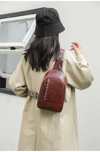 Détail d'un sac bandoulière en similicuir avec rivets et sangle tissée de style ethnique