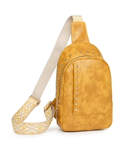 Détail d'un sac de poitrine en cuir jaune à rivets avec bandoulière jacquard ethnique