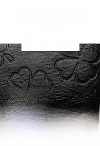 Détail du cuir noir à grain de litchi avec motif trèfle embossé et logo métallique