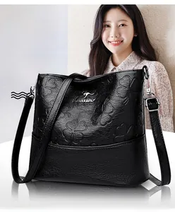 Détail de la texture cuir gaufré trèfle noir et du logo kangourou argenté sur le sac seau