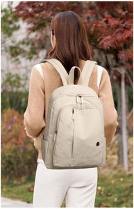 Detailed view of the beige lightweight oxford backpack featuring a large front pocket