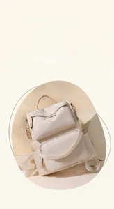 Close-up of cream nylon backpack with leather handles on a soft geometric background