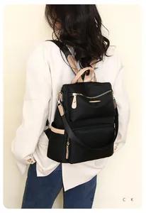Fashionable black nylon anti-theft backpack with beige leather trim and gold zippers