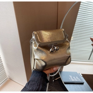 Détail du mini sac bandoulière doré métallisé avec fermoir clic-clac et chaîne fine