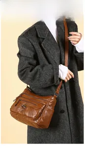 Brown multi-pocket crossbody bag in soft PU leather styled on a model's grey coat