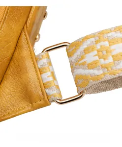 Détail du fermoir en métal doré sur cuir jaune grainé avec bandoulière tissée