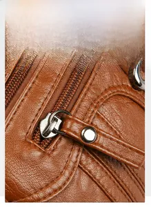Detail of silver alloy zipper puller with brown leather handle on cross-body bag