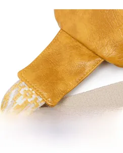 Vue détaillée du sac en cuir jaune avec coutures renforcées et bandoulière géométrique