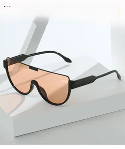 Close-up of oversized one-piece orange lenses with black frame on a geometric stand