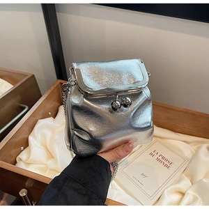 Dettaglio mini borsa a secchiello argento metallizzato con chiusura a sfera e catena