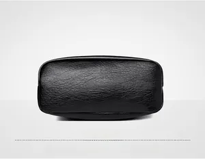 Détail du fond du sac seau en cuir noir souple montrant la texture grainée lychee