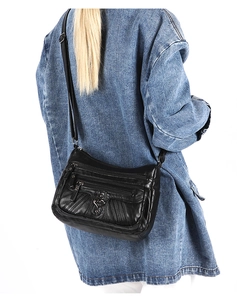 Close-up of black multi-pocket crossbody bag featuring heart-shaped metal buckle and soft leather