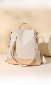 Detail of minimalist beige backpack with camel color contrast and tassel zipper feature
