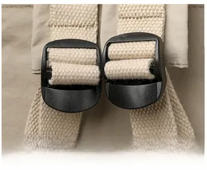 Close-up of adjustable beige canvas shoulder straps with durable black plastic buckles