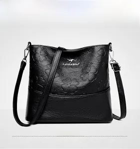 Détail du sac seau noir en cuir grainé avec motifs de trèfle à quatre feuilles embossés