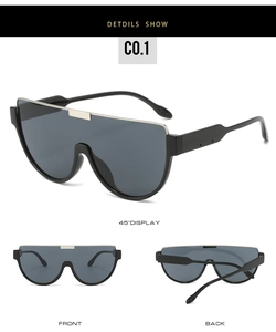 Detail view of oversized sunglasses featuring golden metal trim and dark UV lenses