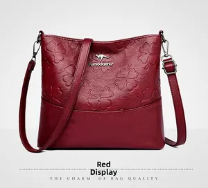 Détail du sac seau bordeaux avec gaufrage trèfle et plaque logo kangourou en métal doré