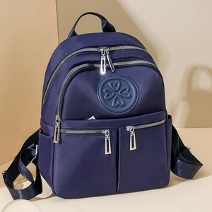 Leichter marineblauer Nylon-Rucksack mit mehreren Taschen und Kleeblatt-Emblem auf Hintergrund