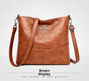 Détail d'un sac seau en similicuir marron avec motifs de trèfles à quatre feuilles
