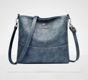 Détail du sac seau bleu en similicuir avec gaufrage trèfle et logo kangourou en métal