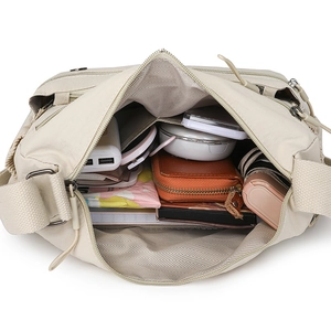 Large beige nylon crossbody bag showing spacious interior with daily essentials