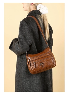 Brown soft leather crossbody bag with multiple zip pockets and heart metal buckle details