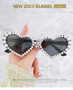 Détail de lunettes de soleil en forme de cœur avec perles et strass rose élégant