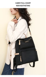 Side view of model wearing a black nylon backpack with light beige leather accents