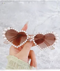 Gros plan de lunettes de soleil en cœur avec bordure en perles et cristaux roses