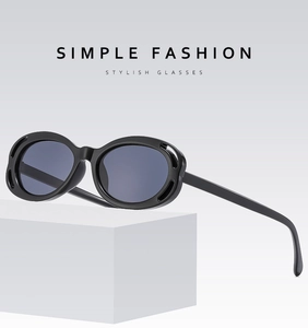 Detail of black oval sunglasses with double hollow frame design on geometric props