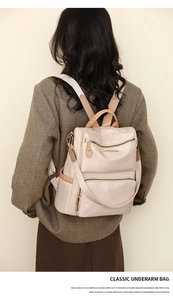 Detail of apricot nylon backpack with gold zippers and pockets on model back