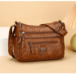 Close-up of vintage brown multi-pocket crossbody bag with heart buckle and pebble texture