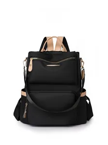 Front view of black nylon backpack with tan synthetic leather trim and zippered pockets