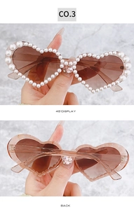 Détails de lunettes coeur avec monture sertie de perles et strass rose sur le pont