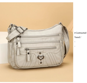 Macro view of multi-pocket soft leather crossbody bag with vintage heart-shaped metal buckle