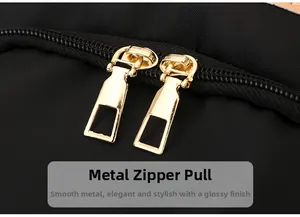 Close-up of durable golden metal zippers on a high-density black nylon travel backpack