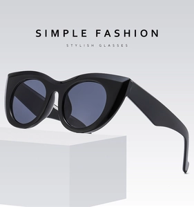 Close-up of stylish black oversized cat-eye sunglasses on geometric display prop