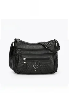 Detailed front view of black faux leather crossbody bag with multiple zip pockets