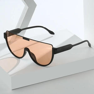 Modern oversized one-piece sunglasses with orange lenses and black frame on white stand